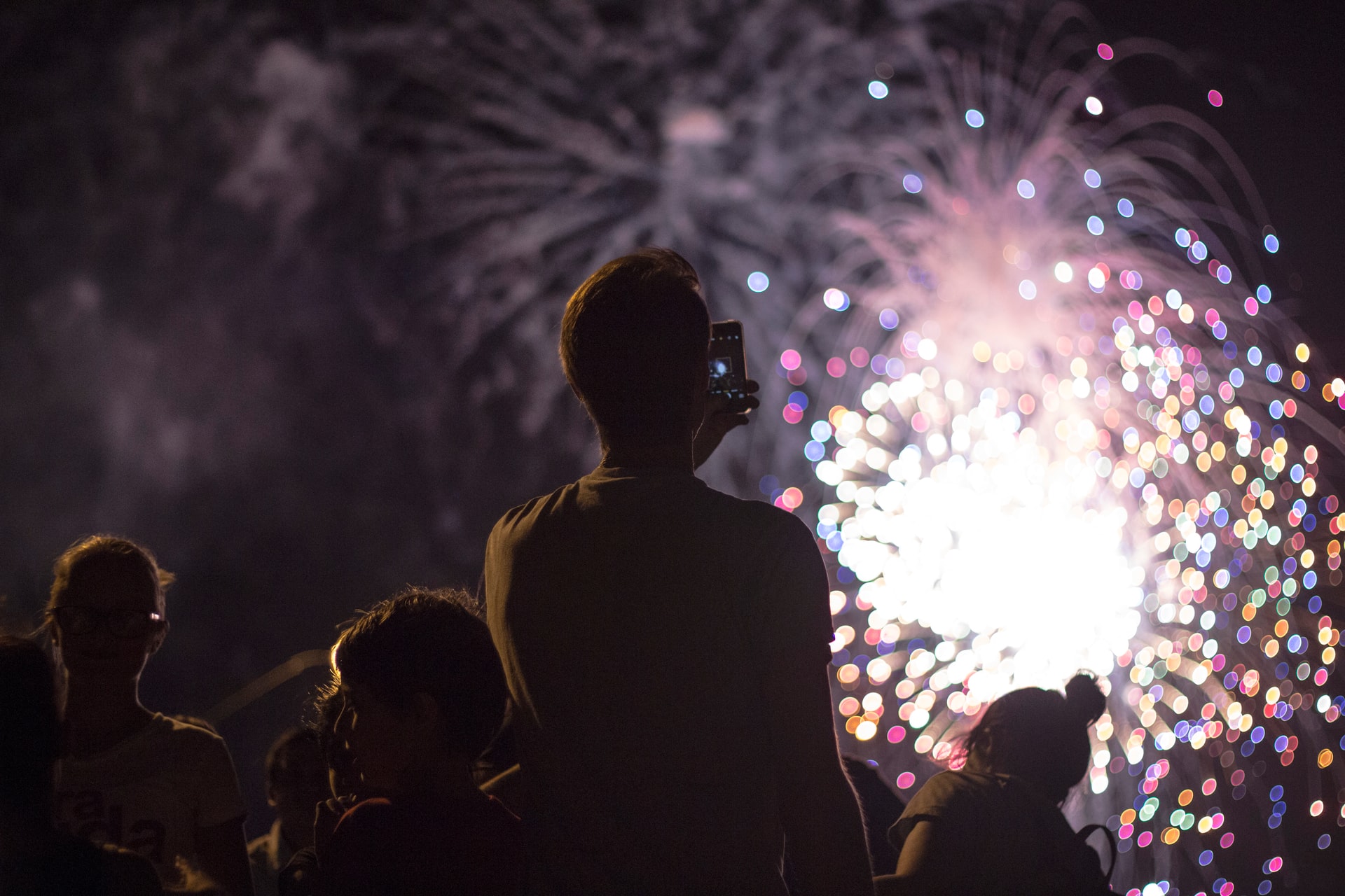person taking photos of fireworks display