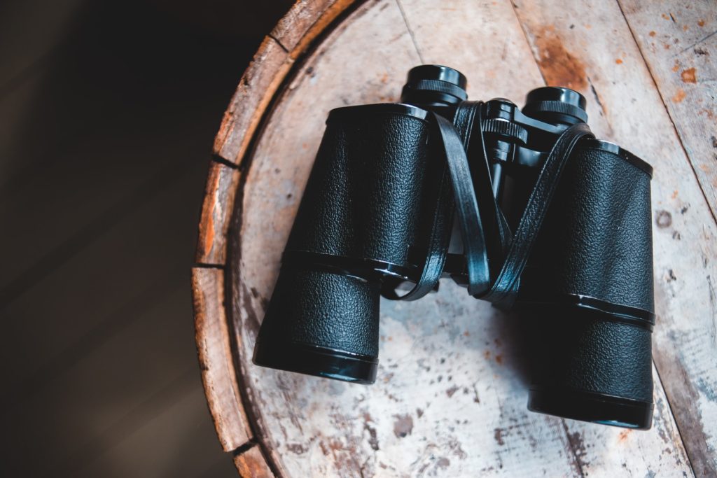 binoculars on wooden surface