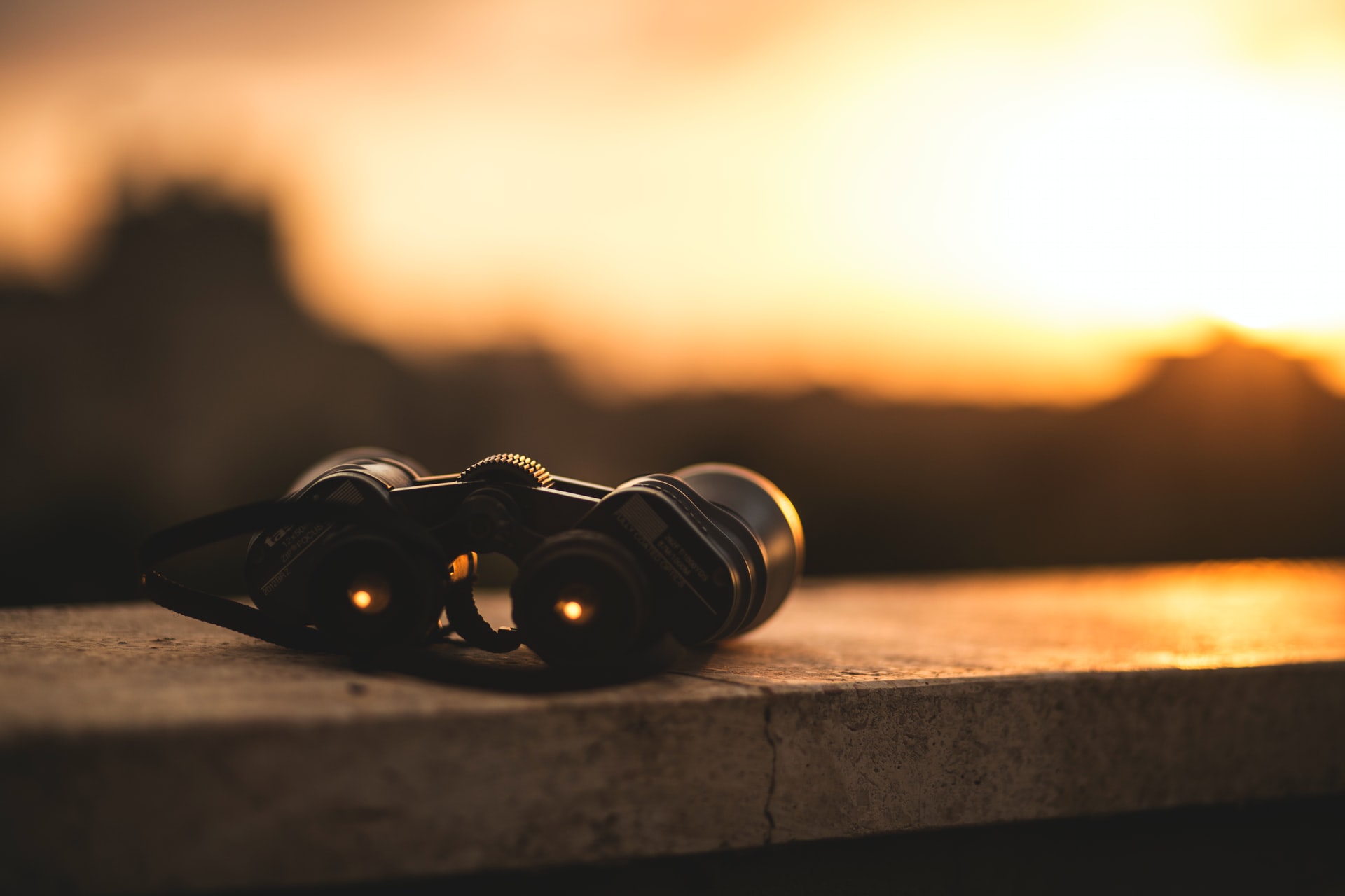 binoculars on wall at sunset, beginners guide to binoculars